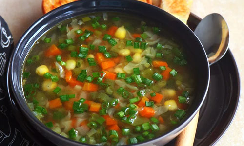 Hot clear soup broth with sliced carrots and celery